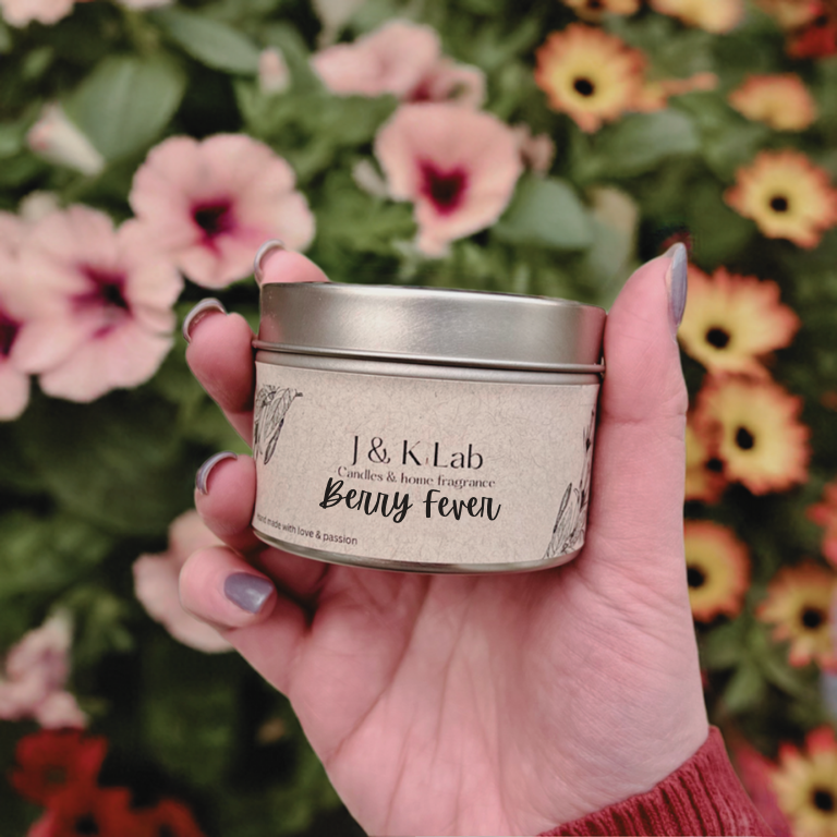 J&K Lab Travel Tin Candle -Berry and Vanilla Scent - Held in Front of Flowers