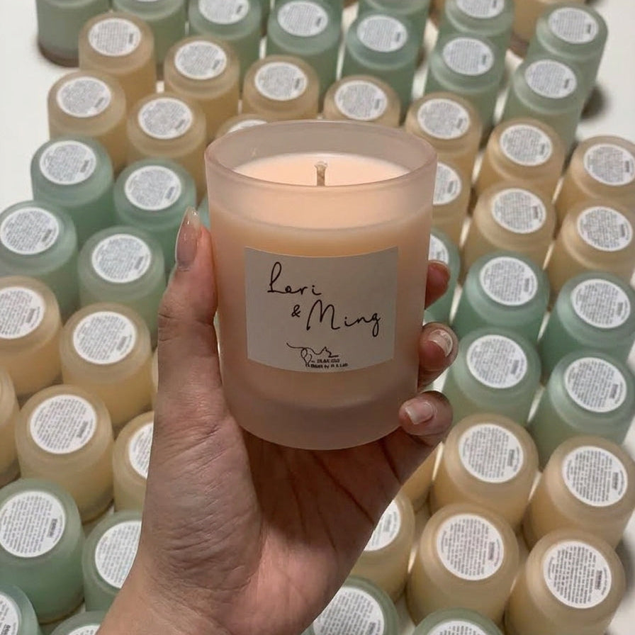 Bespoke wedding favor soy candles with custom dyed wax, personalized couple labels, and matching lids